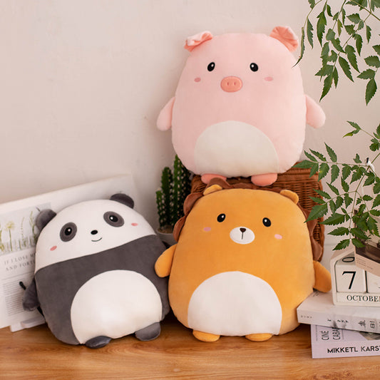 Three cute animal plush toys on a wooden surface with a plant in the background.