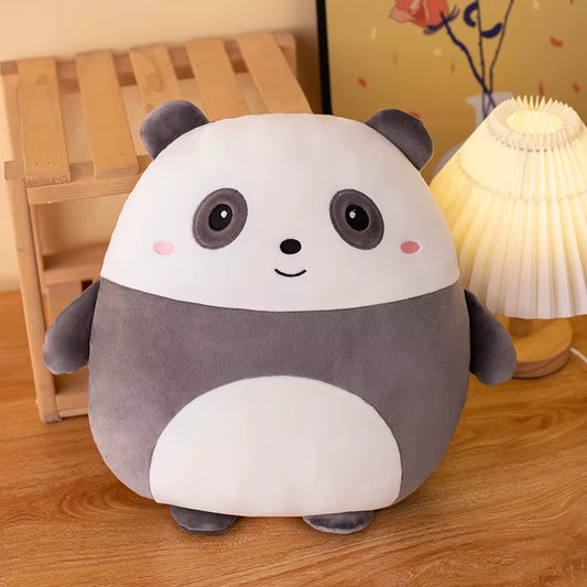 Cute plush panda toy on a wooden surface with a lamp in the background